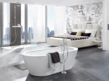 独立椭圆形钢瓷浴缸配毛巾，背景为现代淋浴区，明亮空间设计