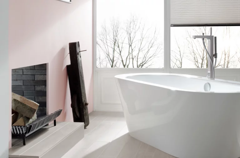 现代浴室中独立椭圆形钢瓷浴缸，木纹瓷砖，大量自然光