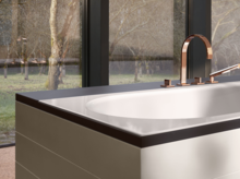 Rechteckige Badewanne aus Stahl-Email mit moderner Armatur, steht frei vor großen Fenstern mit Blick ins Grüne.
