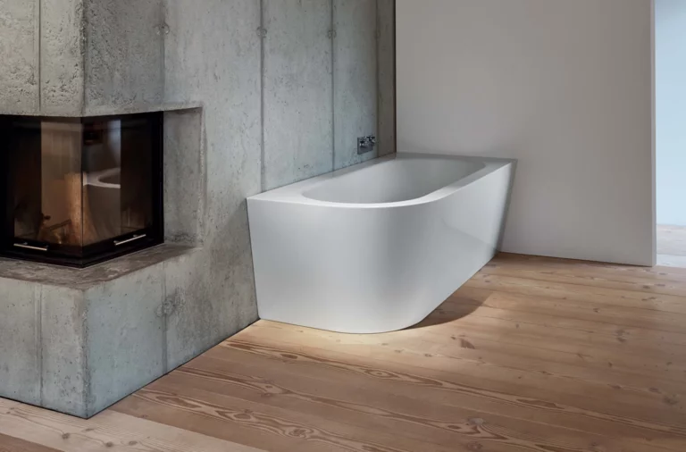 Freistehende, rechteckige Badewanne aus Stahl-Email mit abgerundeter Vorderseite in modernem Badezimmer mit Kamin.