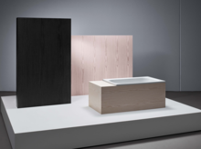 Vasca da bagno rettangolare in acciaio smaltato con rivestimento in legno su podio, design minimalista, colori neutri.