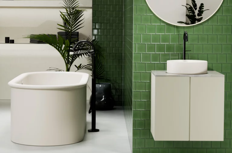 Runde Stahl-Email-Badewanne und rundes Waschbecken auf Einbauplatte, modernes Bad mit grünen Wandfliesen.