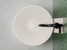 圆形搪瓷钢洗手盆配黑色龙头，安装在绿色瓷砖墙上。