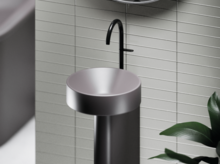 圆形独立钢瓷洗手盆配黑色水龙头，浅色瓷砖背景，现代风格。