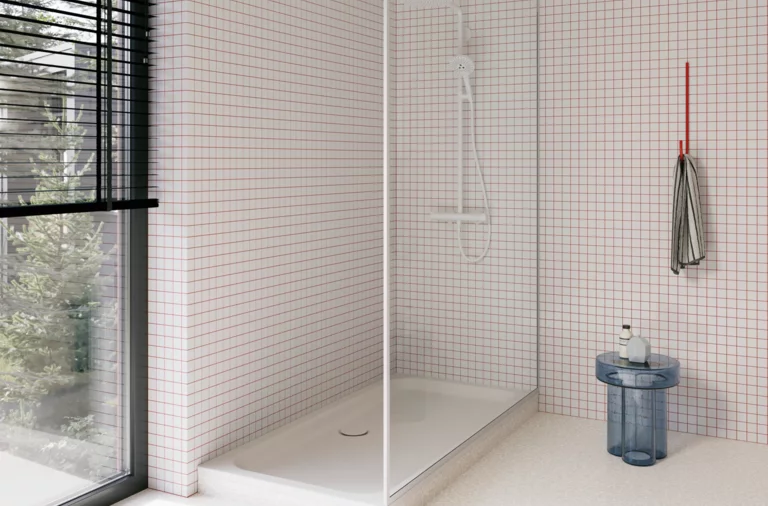 Weiße Duschwanne in einer hellen, bodengleichen Dusche mit weißen Mosaikfliesen, Glasabtrennung und großem Fenster.