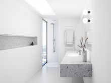 Helles, minimalistisches Bad mit weißer Duschwanne, Waschbecken auf Terrazzoplatte, Wandnische und bodentiefem Fenster.