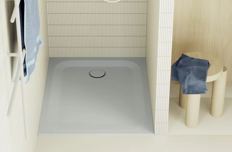 Square light blue shower tray with wall tiles, towel rack, and stool with clothes in a modern bathroom.