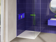 Dusche mit weißer Duschwanne, lila Wandfliesen, grüner Armatur und integrierter Ablage in modernem Bad.
