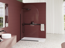Modernes Bad mit offener Dusche, bordeauxfarbenen Fliesen, schwarzer Armatur, Haltegriff und hellem Terrazzo-Boden.