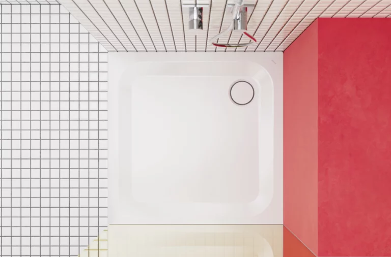 Quadratische Duschwanne mit wandbündiger Armatur, kombiniert mit weißen Fliesen und roter Wand in modernem Design.