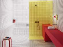 Modernes Bad mit gelb gefliester Dusche, rotem Waschtisch, weißem Aufsatzbecken und durchgehendem Rasterfliesen-Design.