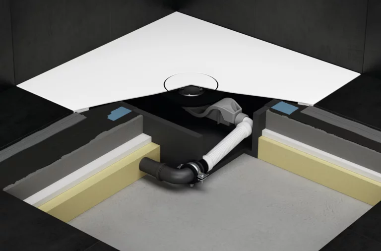 Piatto doccia ad angolo con box d’installazione e scarico flessibile sotto il pavimento piastrellato.