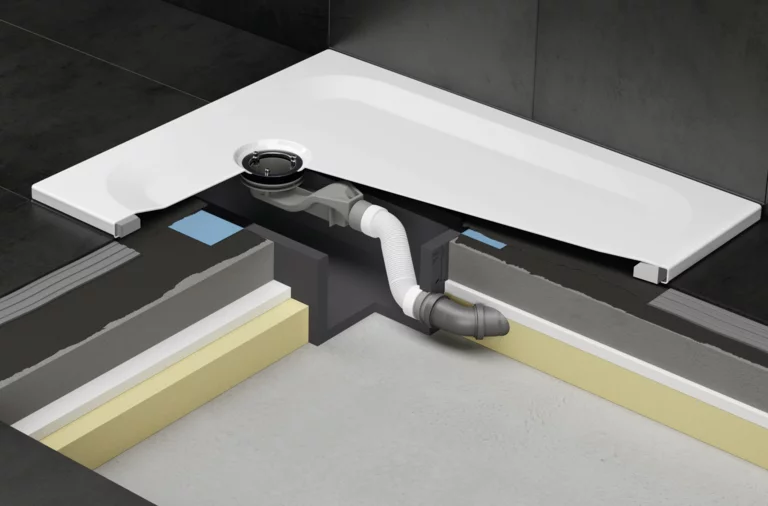 Partially exposed shower tray with drain connection in installation box under the tiled floor structure.