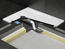 Gedeeltelijk zichtbare douchebak met afvoer in installatiebox onder de betegelde vloeropbouw.